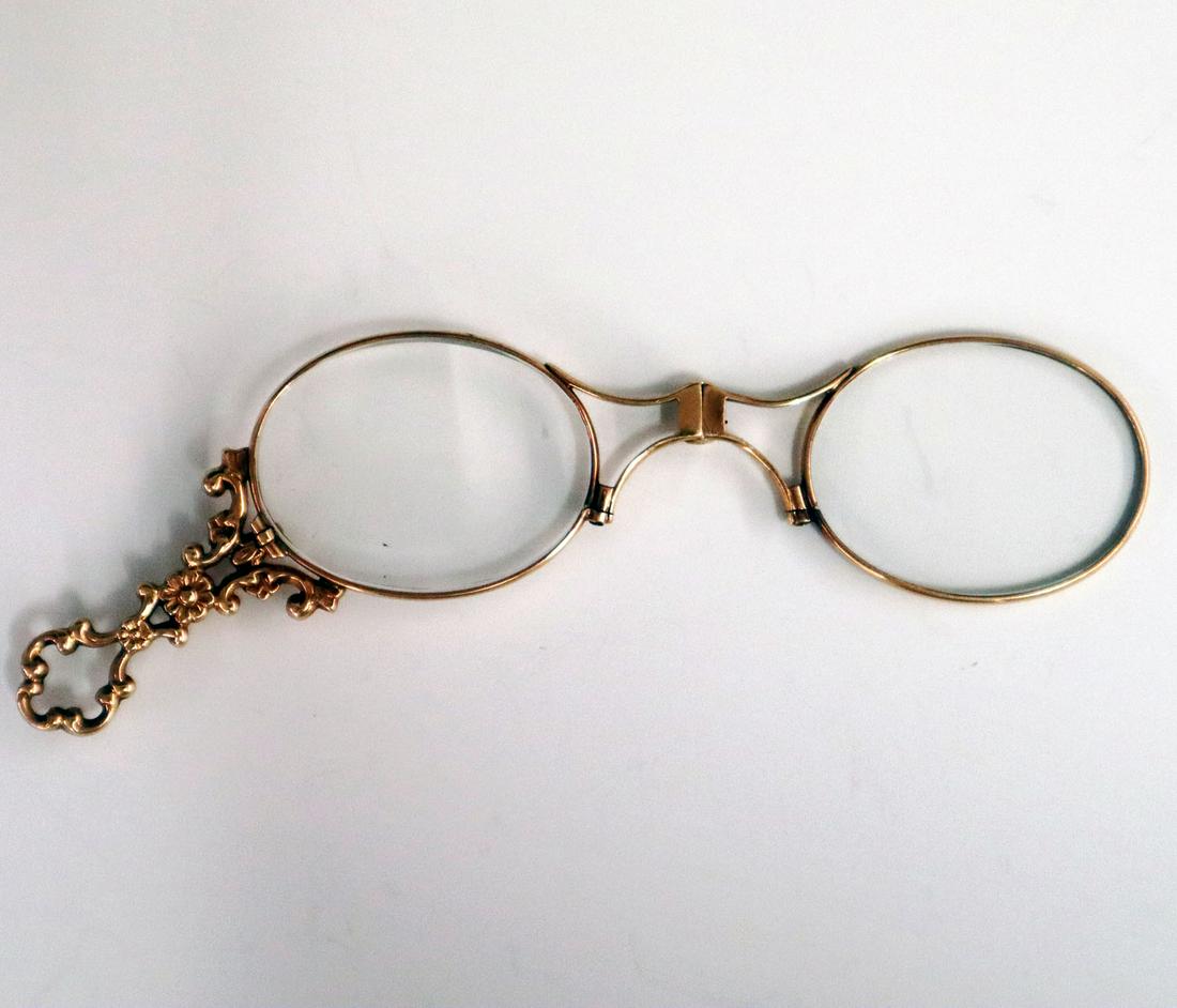 14 kt Gold Lorgnette: A Turn of the Century 14 kt Yellow Gold Lorgnette. Having a filigree handle with oval lenses. Marked "14" on bridge. Minor scratches on lenses. 5" long (open). 16 grams total weight. ESTIMATE $400-600