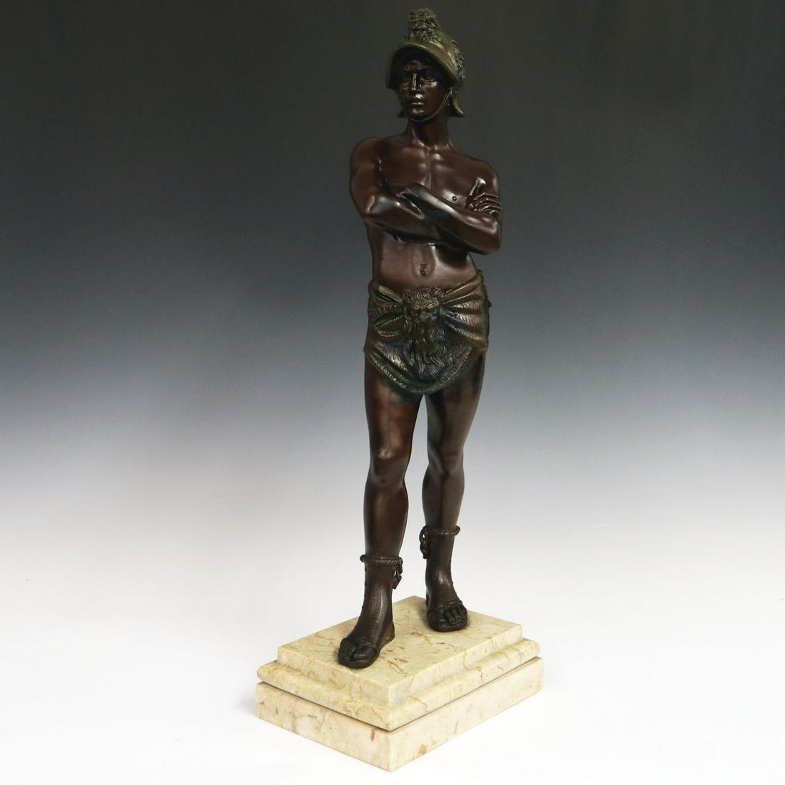 Bronze Roman Gladiator: A Turn of the Century Bronze Sculpture. Two patina bronze sculpture depicting a Roman Gladiator shown with his arms crossed and wearing a helmet and garment both with lion detail, situated atop a marb