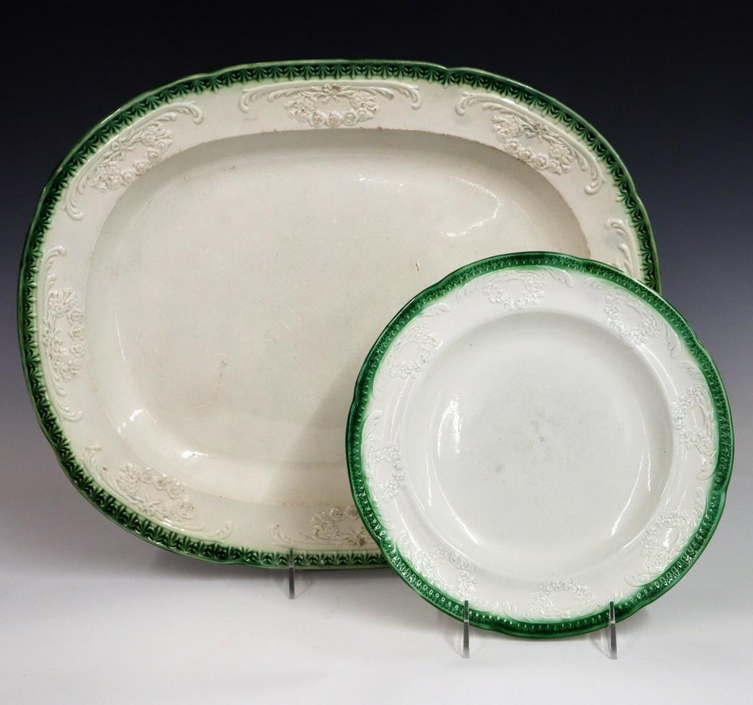 2 Ironstone Serving Pieces: Two Mid 19th Century Ironstone Serving Pieces. Including 1 Clews dinner plate with embossed wreath and floral decoration and 1 unmarked platter with the same motif. Both pieces with green feather edge