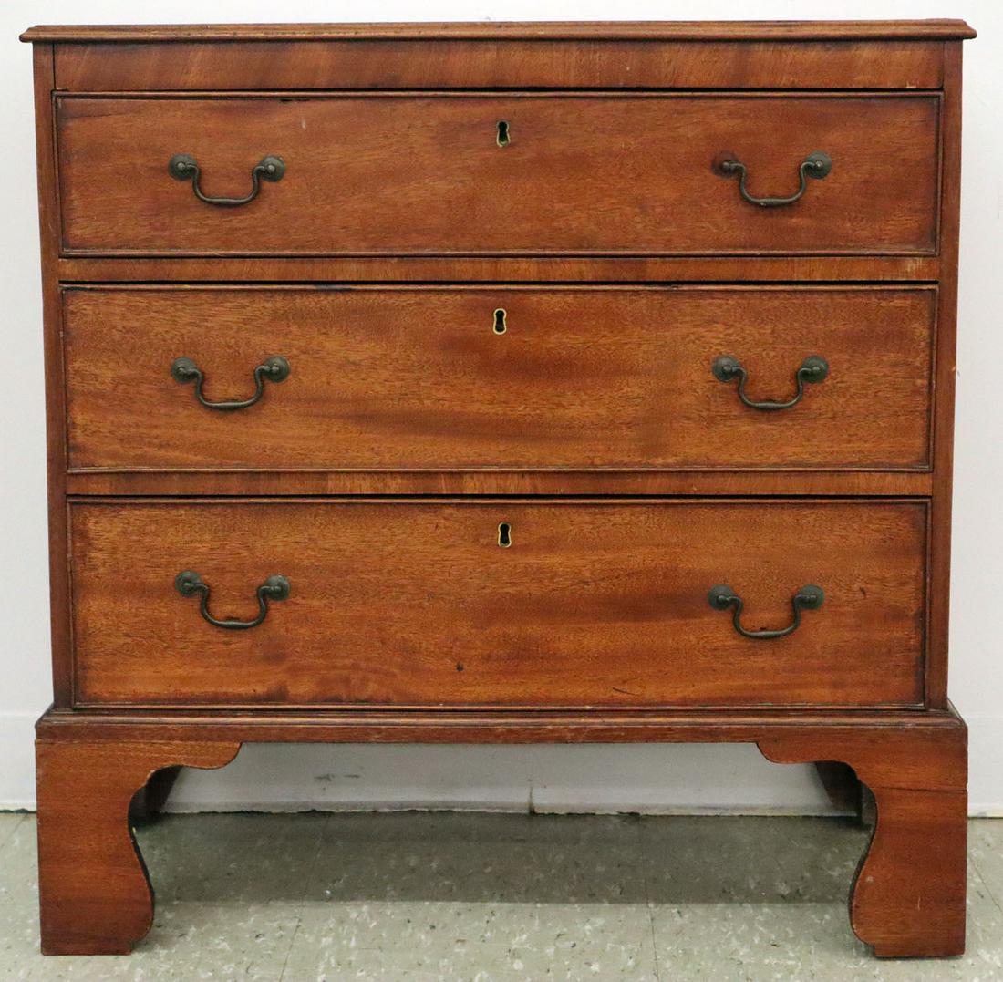 George III Chest of Drawers: An Early 19th Century George III Chest of Drawers. Three drawer mahogany chest with old finish, brass bail hardware on tall bracket feet. Wear to finish, cracks to sides and feet, old repairs to two f