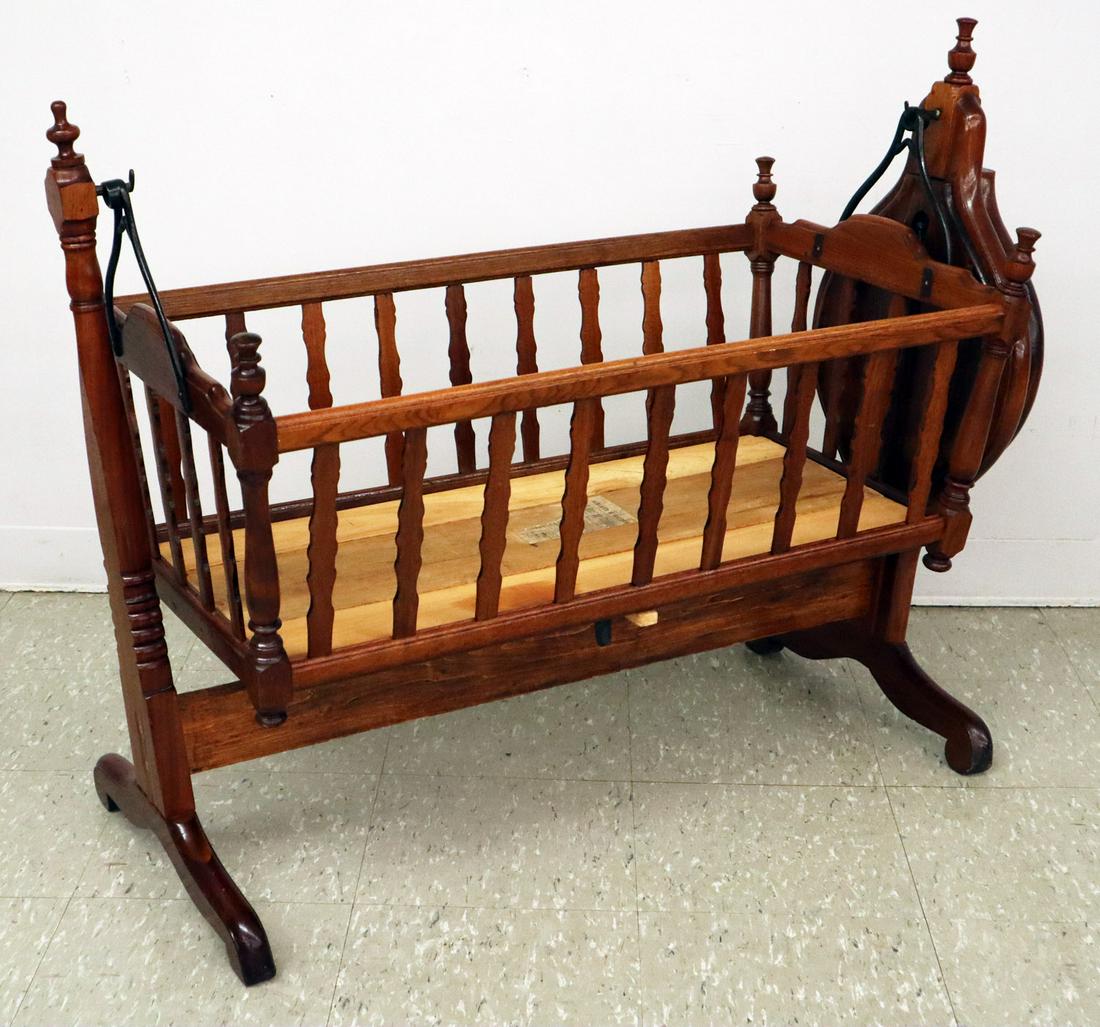 Self-Rocking Cradle: A Late 19th Century Walnut Self-Rocking Cradle. Made by Walker & Sneden, No. 85 McWhorter Street, Newark, N.J. Includes a partial label at the interior and a clockwork rocking mechanism. Older refinis