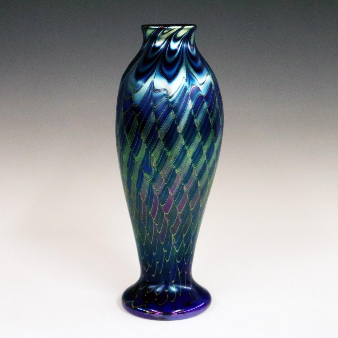Orient & Flume Glass Vase: A Late 20th Century Orient & Flume Art Glass Vase. Having a pulled feather and diamond form pattern about the whole in blue, green, and purple on an iridescent blue ground. Etched mark of "Orient & Fl