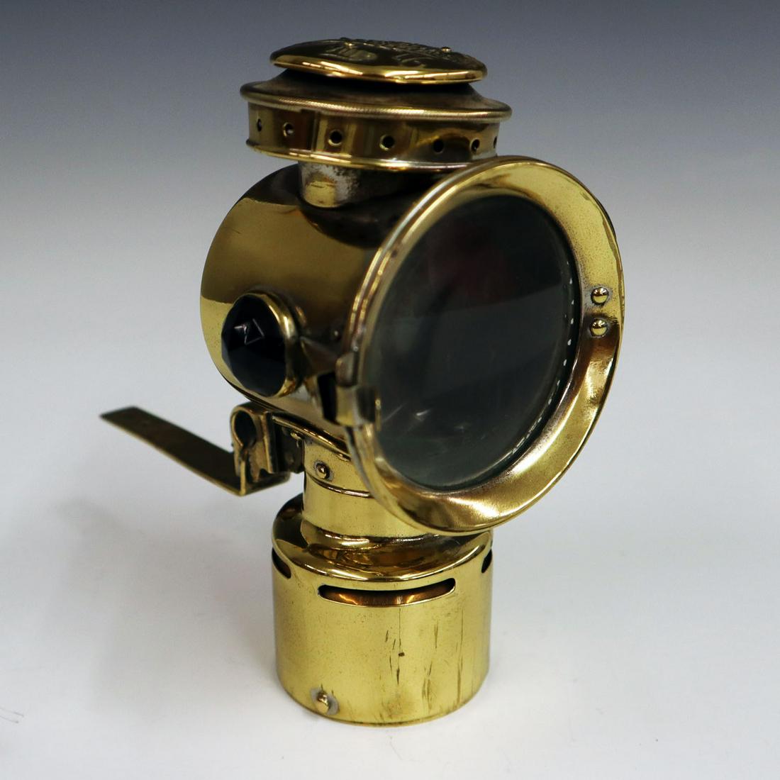 "Never Out" Bicycle Lamp & Bracket: An Early 20th Century "Never Out" Bicycle Lamp & Bracket. Polished brass lamp by Rose Manufacturing, Philadelphia, PA, with bracket. Some dents at the back of the lamp, was originally nickel plated. 6