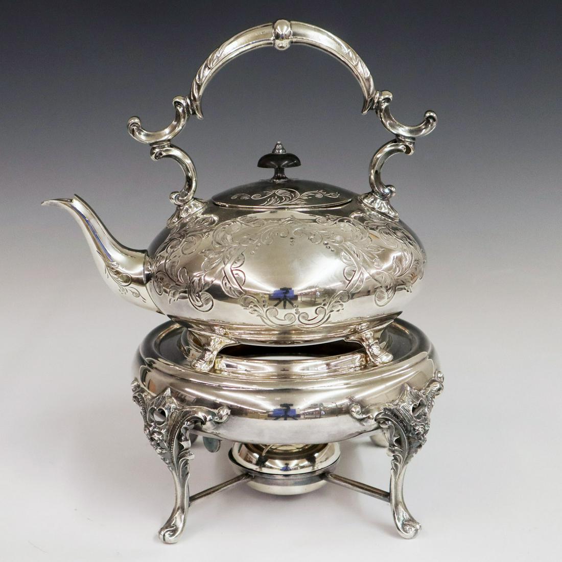 Silver plate tea kettle & stand: An Early 20th Century Silver Plate Tea Kettle & Stand. Having an engraved tea kettle with hinged cover and a warming stand with burner. The kettle is marked "Winchester Hand Engraved Sheffield England