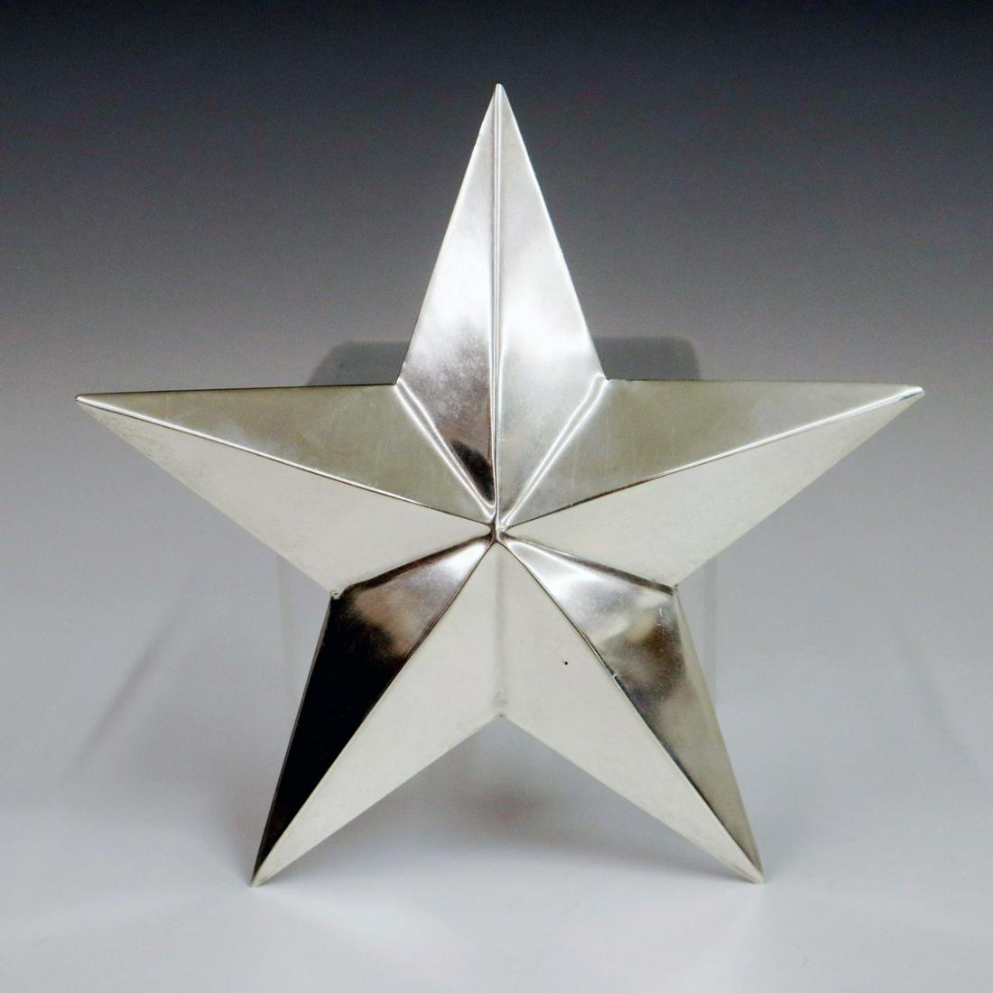 Cartier Sterling Ornament: A Late 20th Century Cartier Sterling Ornament. Star shaped holiday tree ornament with hanging hook at back. Stamped "Cartier Sterling" enclosed within a circle verso. Minor surface wear. 5 3/4" high. 