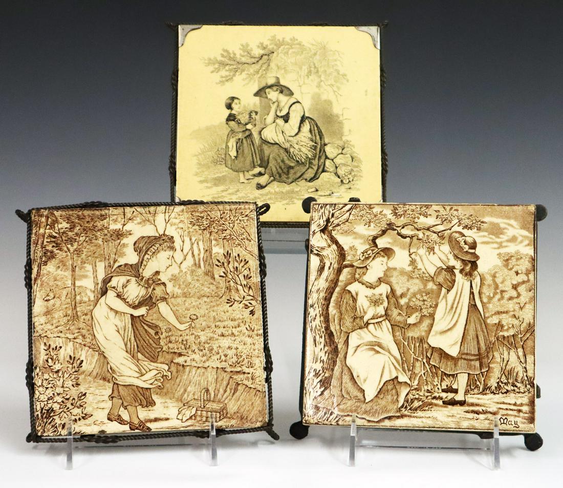 3 Tile Trivets: Three Late 19th Century Tile Trivets. Including 2 Josiah Wedgwood sepia transfer tiles and 1 black transfer unmarked tile; set within either a wire or iron base. Minor staining to tiles, one with a 2"