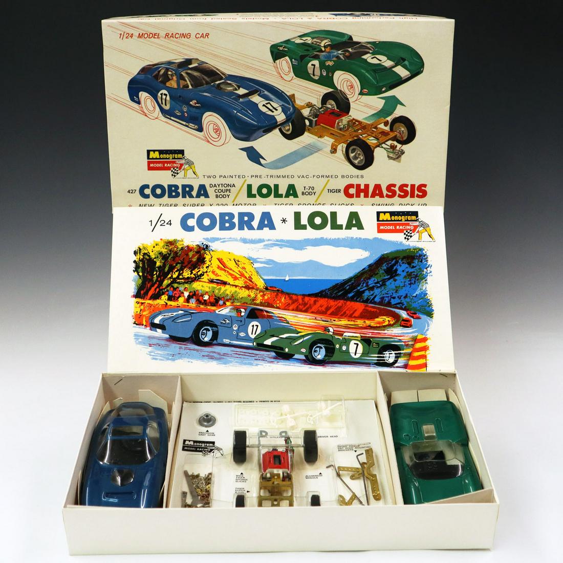1960s Monogram Cobra/Lola Model Kit: A 1960s Monogram Cobra/Lola 1/24 Scale Racing Slot Model Kit. Includes 2 bodies and one chassis. In original packaging and box, never assembled. Wear to box and minor dents. Box is 14 1/2" x 8" x 2 1/