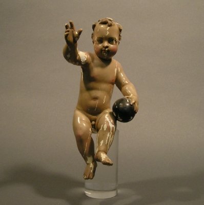 Santos: A 19th century Spanish Colonial carved wooden Santos of the Christ Child with a Sphere in his hand. Original gesso and painted surface. Wear, flaking and older restoration. On a Lucite stand, 10 1/4"