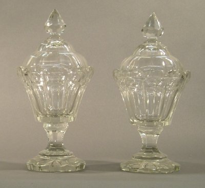 Pair of Crystal Jars: A pair of turn of the century Crystal covered jars. Paneled lids and bodies with Star Cut bases. Minor wear. Each 11" high.