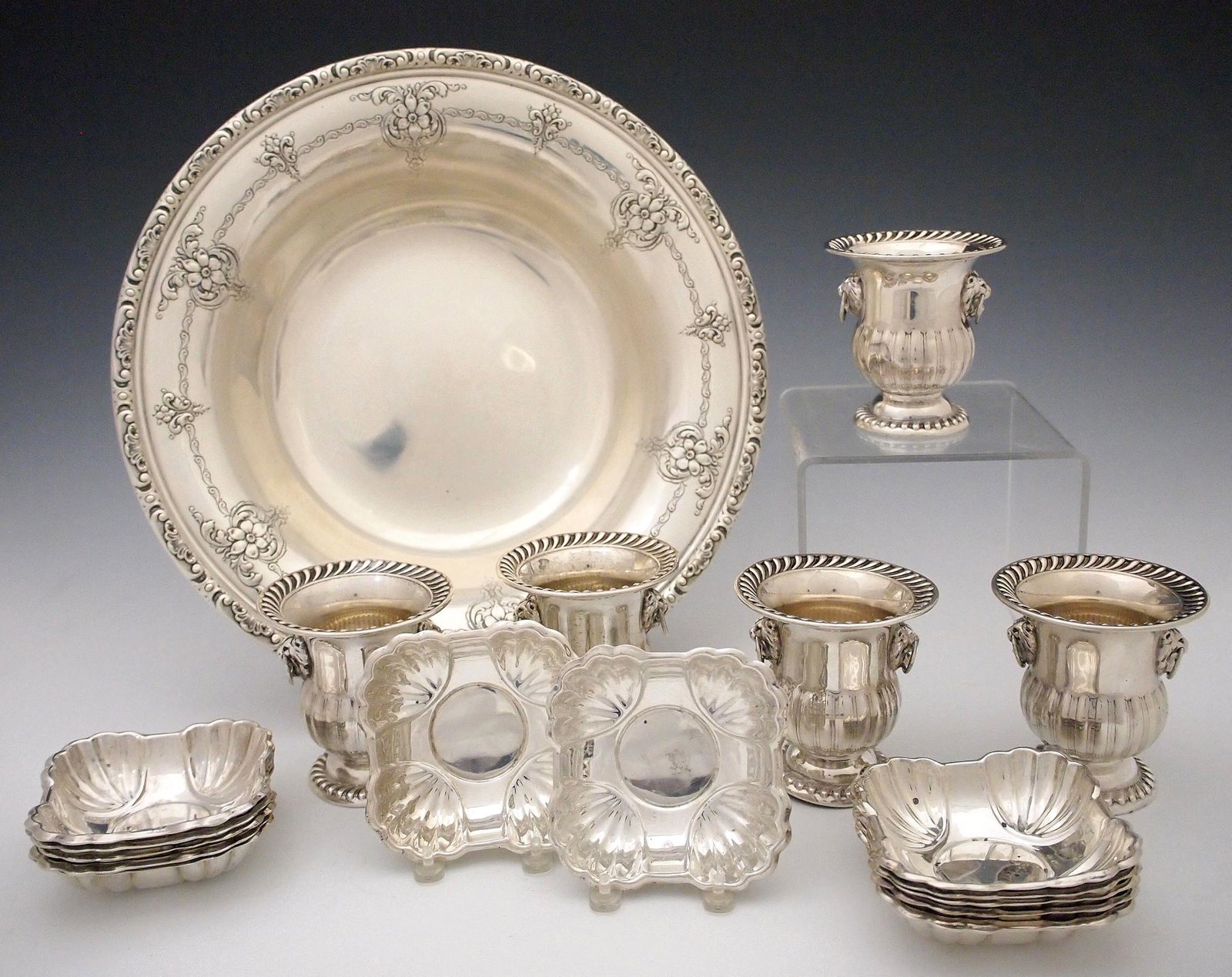 18 pc Sterling Tableware: Eighteen pieces of 20th century Sterling Silver tableware. Includes a 10 1/4" Towle bowl, twelve Rogers Bros. individual nut dishes and five National footed cups with Lion's mask handles. 33.23 Troy O
