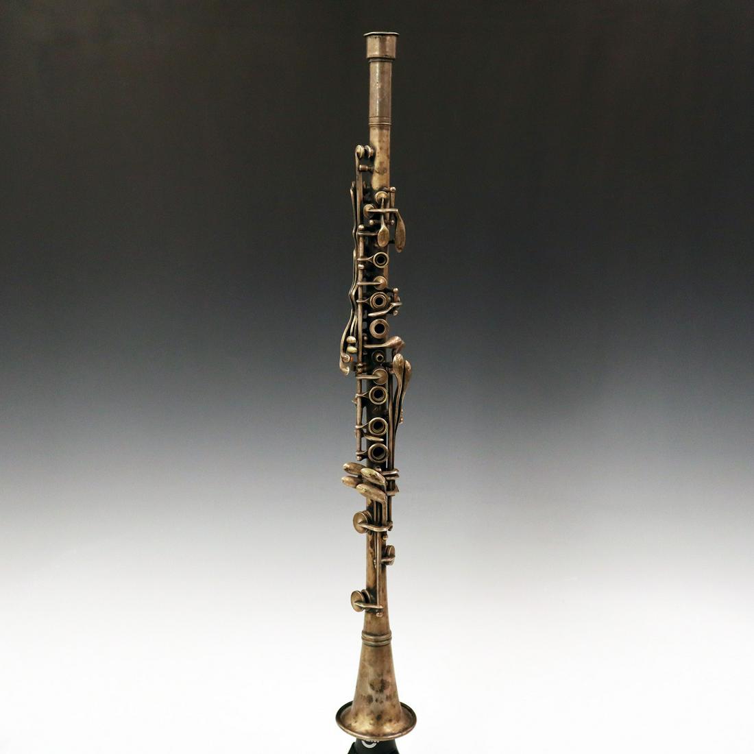 1920's H. Bettoney Clarinet: A 1920's H. Bettoney Clarinet. Silver plate instrument is engraved "USQMC" on bell, serial no. A-866. Some wear, worn and missing felt pads, lacks mouthpiece. 22 3/4" high. ESTIMATE $50-100