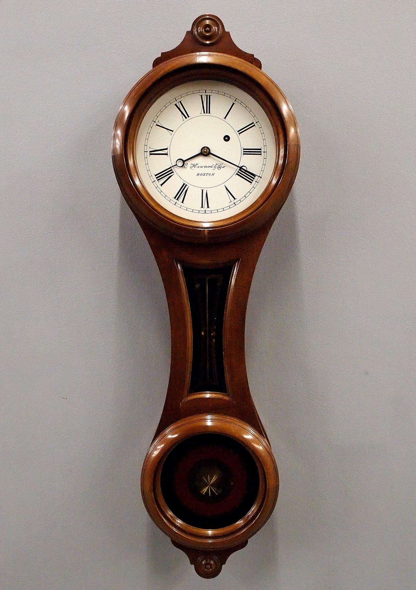 E. Howard & Co. Re-Issue No. 10 Figure 8 Wall Clock: An E. Howard & Co. Re-Issue No. 10 figure eight wall clock. 8-day weight driven time only movement with a painted metal dial. Walnut case with a single shaped door and original reverse painted glasses