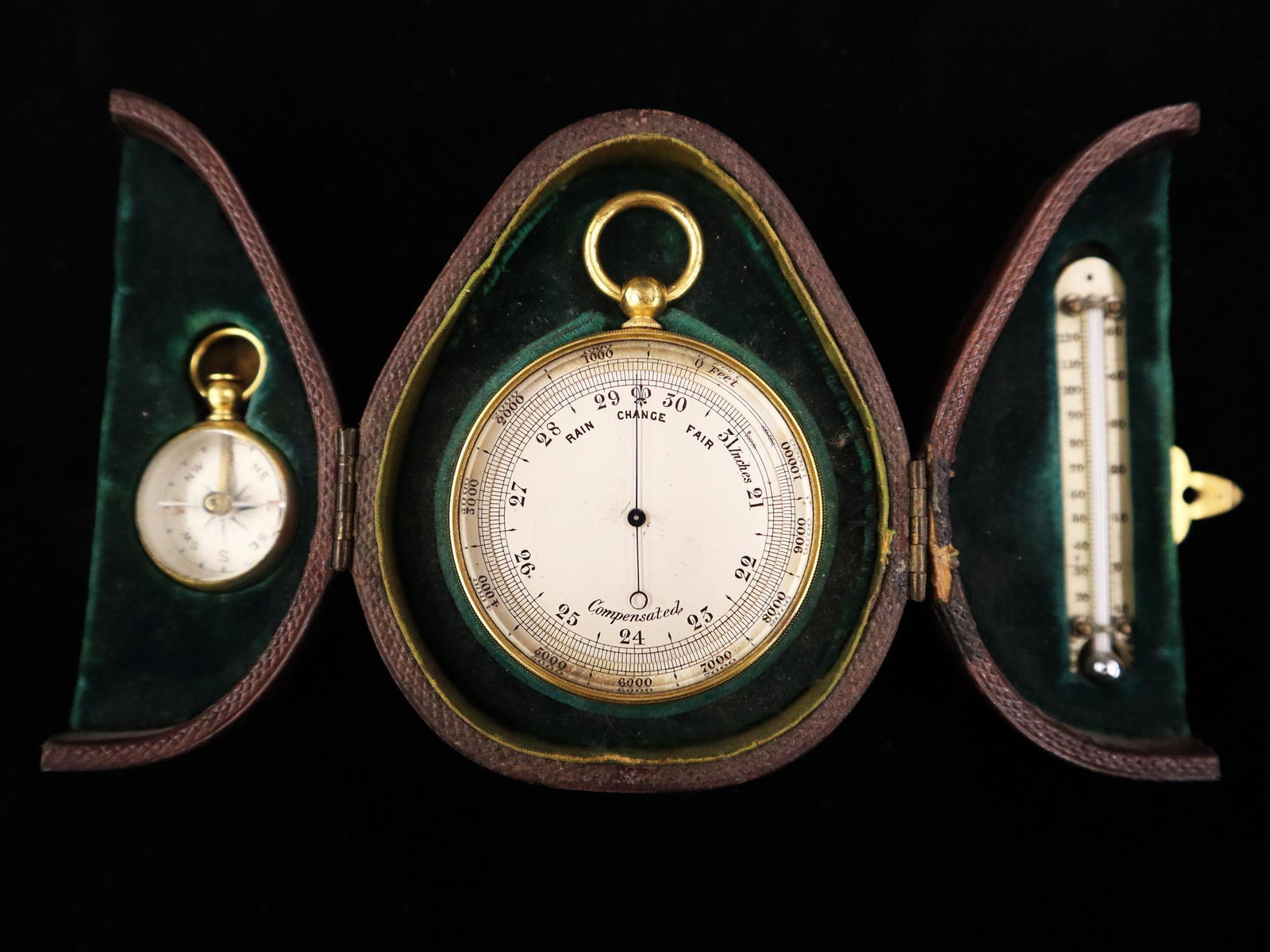 19th Century Pocket Barometer: A 19th century Pocket Barometer. Brass compensated barometer with silver and painted dial together with a small compass and thermometer, in a fitted pear shaped leather case. Some discoloration to the