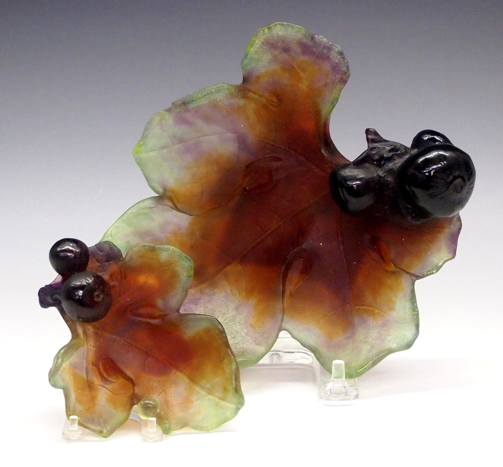 2 Daum Dishes: Two Daum Pate de Verre Dishes. Both having a fig leaf and fig design with colors of Amber, Green, and Amethyst the smaller with a small figure of a snail and the larger is enhanced with a lizard. Each