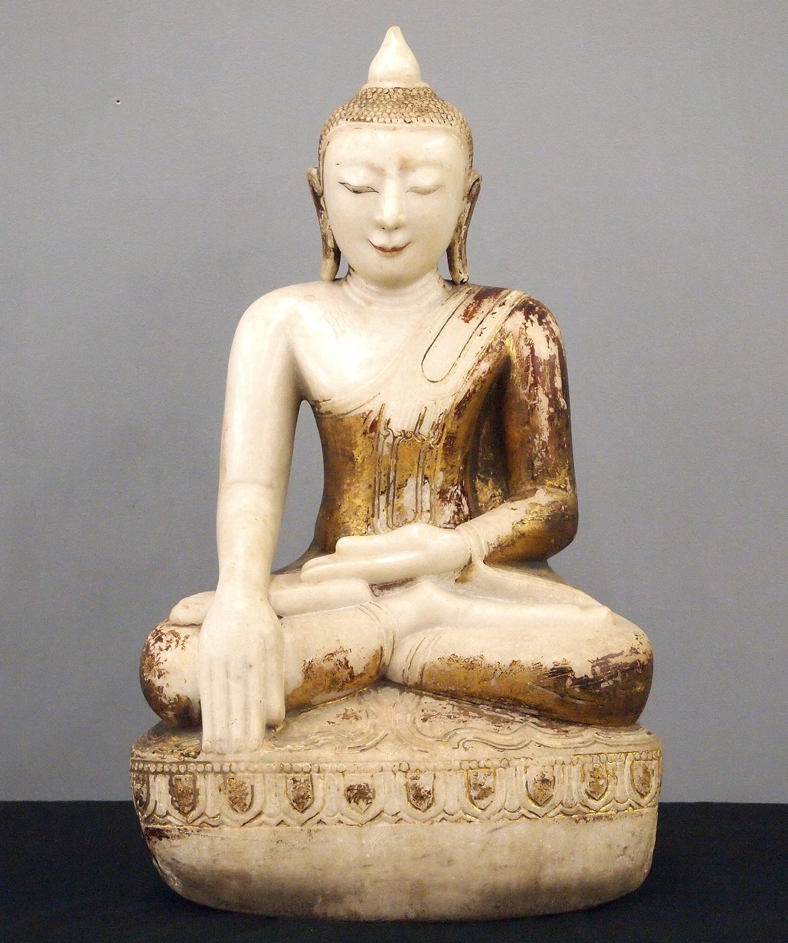 Carved Marble Buddha: An early 20th century carved Marble figure of a seated Buddha. Multi-layer paint and gilded finish with much wear and some losses. 31" high overall. ESTIMATE $600-800