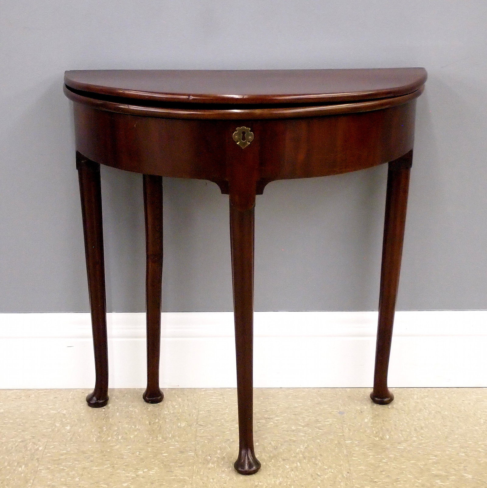 George II Tea Table: An 18th century English George II Period tea table. Mahogany with double hinged demilune top with a lower open well fitted with pen and inkwell compartments, base with turned legs and simple pad feet,