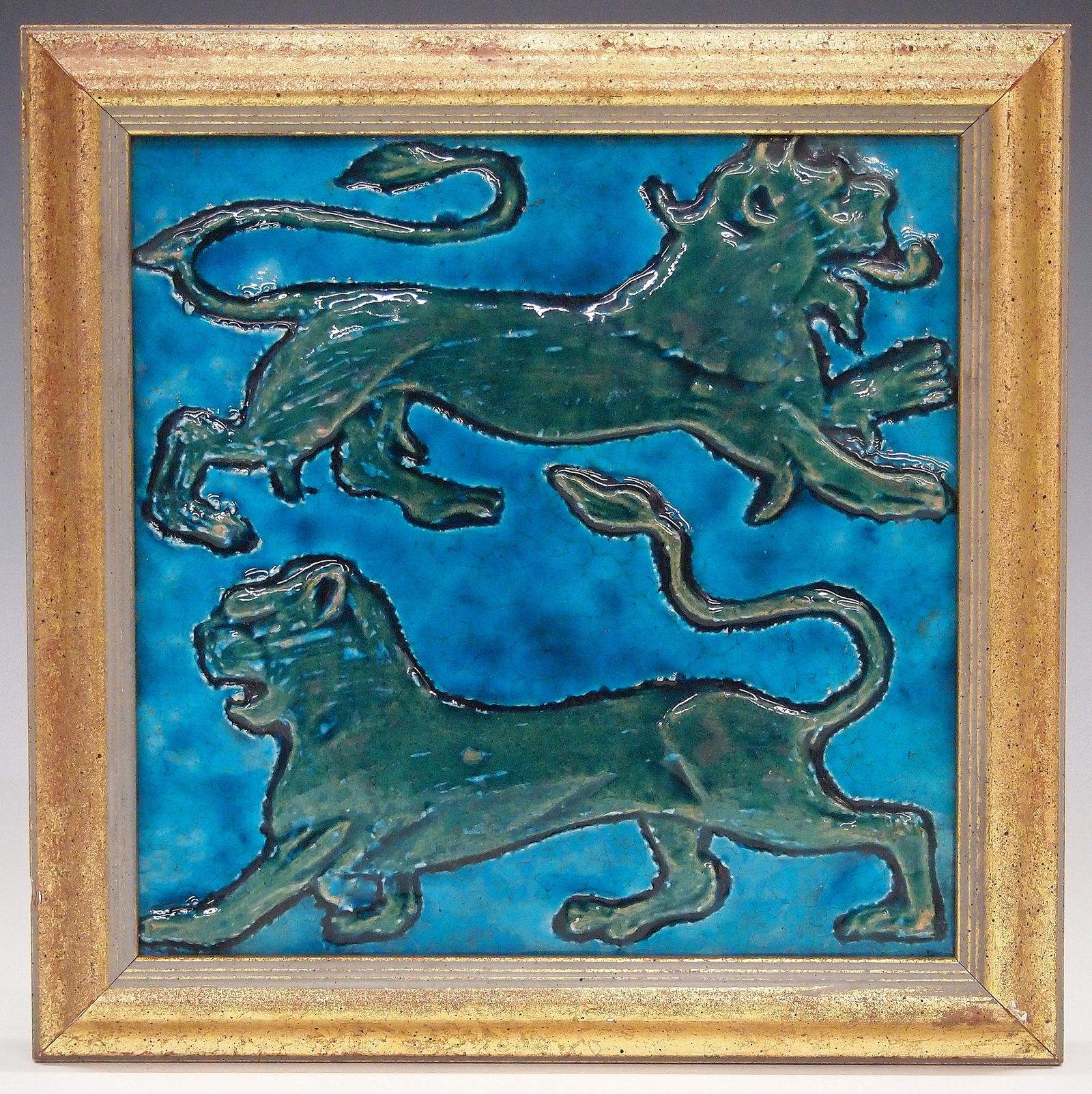 W. De Morgan Tile: A late 19th century William De Morgan Art Pottery tile. "Lion and Lioness" tile with Greenish-Blue felines against a Turquoise ground. Impressed oval "De Morgan" mark verso. Crazing, some surface scra