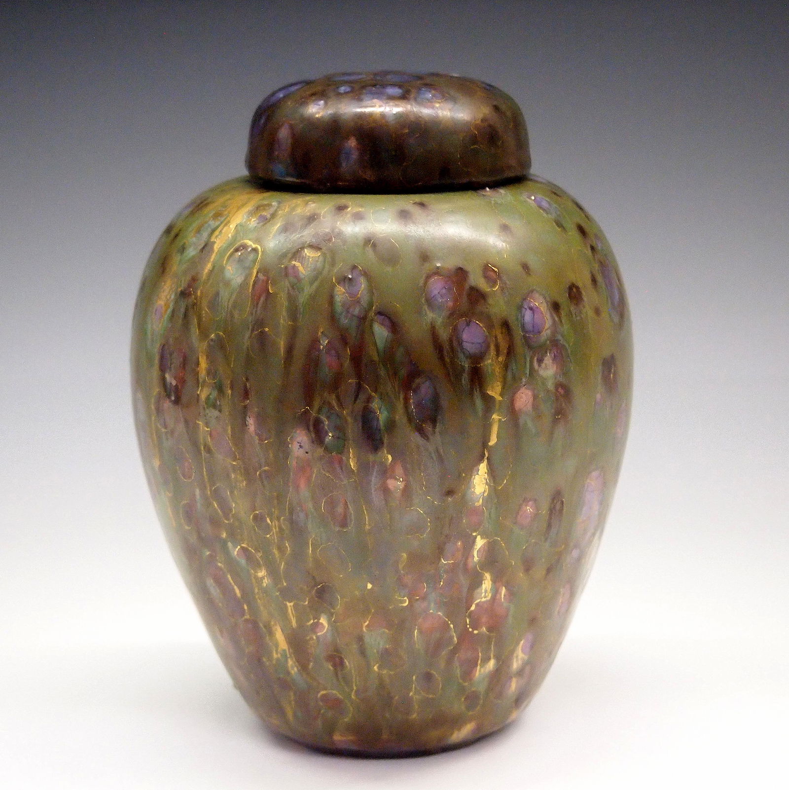 Massier Covered Vase: An early 20th century Clement Massier covered vase. Traditional Ginger jar form with a short domed cover in a Green/Gold mottled glaze. Faint incised "C M" incised mark under glaze. Wear and some craz