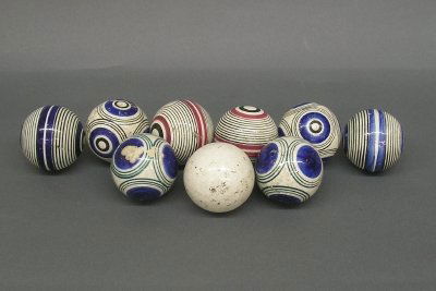 9 Carpet bowls: A set of nine late 19th century Scottish carpet bowls. Four pairs of multi patterned earthenware bowls and a plain White jack. All with some glaze and surface chips and general wear. Each 2 1/2" diame