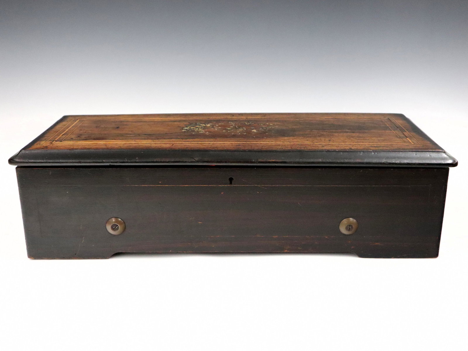 Swiss Cylinder Music Box: An early 20th century Swiss cylinder music box. Multi-tune spring driven mechanism in an inlaid Rosewood case with painted detail. Case wear, some damage, lacks several teeth, running when cataloged. 