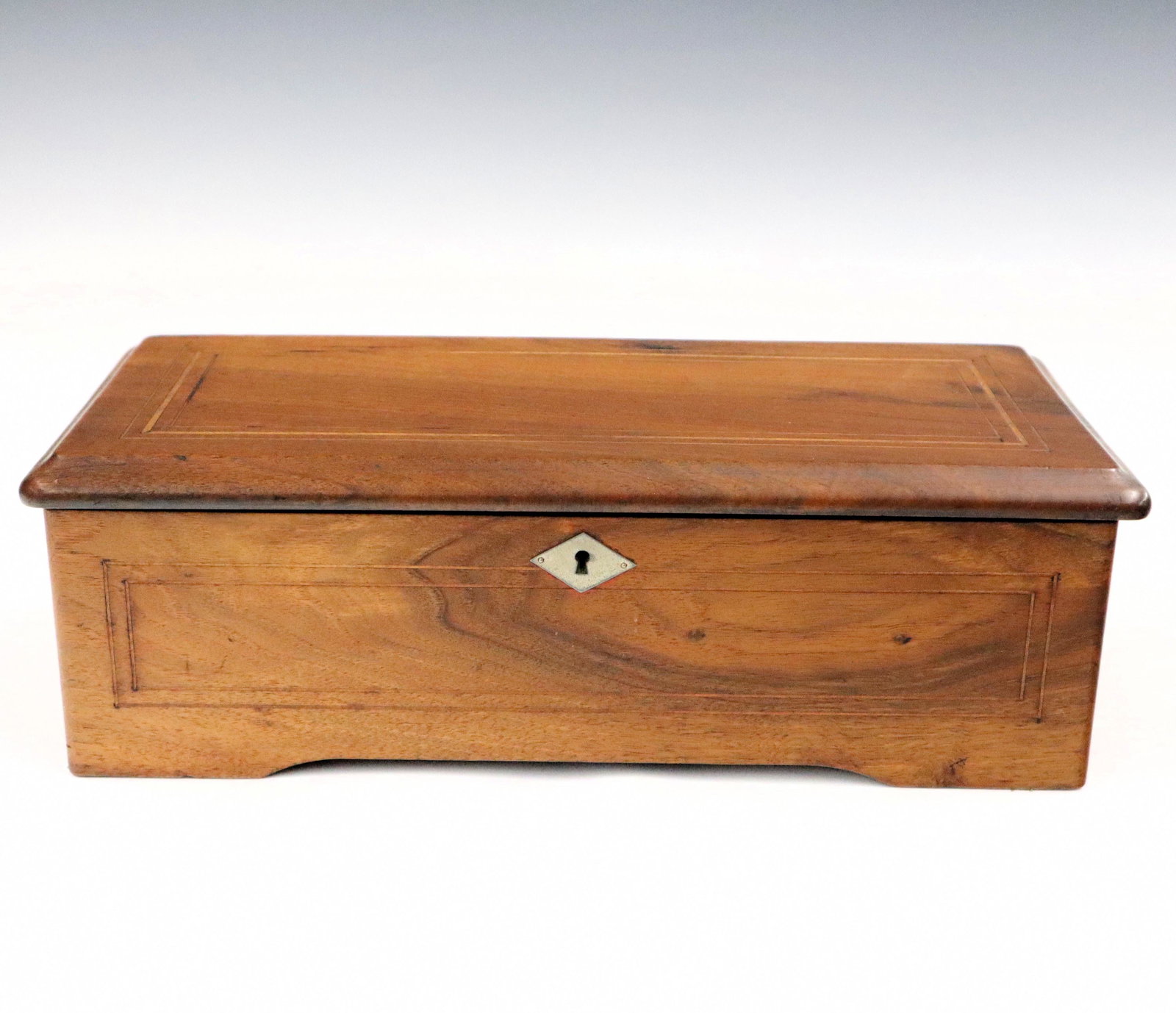 Swiss Cylinder Music Box: An early 20th century Swiss cylinder music box. Multi-tune spring driven mechanism in an inlaid Mahogany case. Refinished with some wear, lacks on/off escutcheon running when cataloged. 15 3/4" long. 