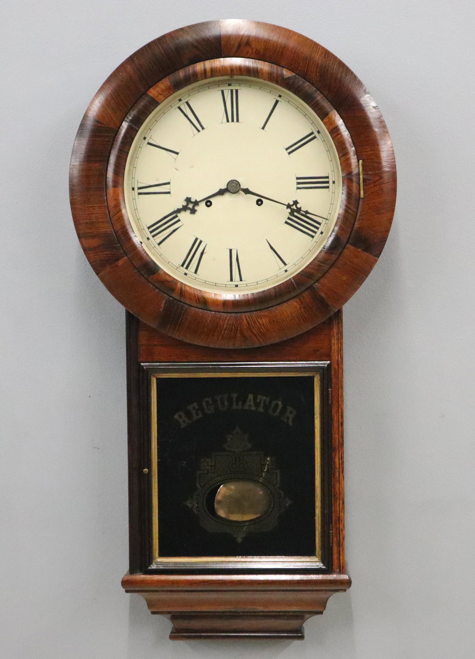 E N Welch No. 3 Regulator: A 19th century E. N. Welch "No. 3 Regulator" model wall clock. 8-day dual weight time only movement with painted metal dial with Roman numerals. Rosewood case with a circular upper door over a lower d