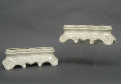 Pr Nymphenburg bulb pots: A pair of Nymphenburg porcelain Rococo style bulb pots. White molded bodies with double bulb openings. Printed and impressed marks. Minor wear. Each 10" long. ESTIMATE $100-200
