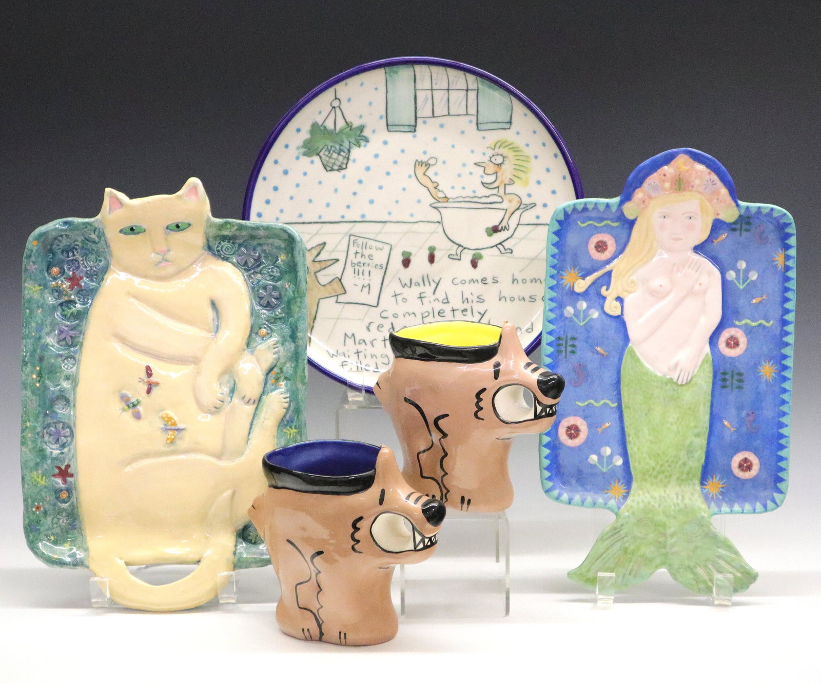 Art Pottery Dishes & Trays: A group of late 20th century art pottery dishes. Includes two whimsical trays by Pewabic artist Laurie Eisenhardt, two comic style dog mugs by Belinda Gabryl, and a Wallyware plate featuring Martha St