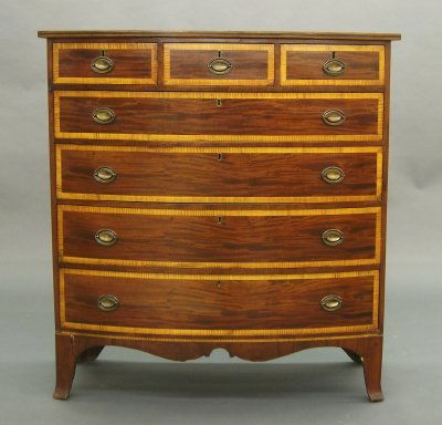 Hepplewhite chest: A late 18th century American Hepplewhite Mahogany chest. Bow front design with two short over four long drawers, all with contrasting banding, over a scalloped apron and French bracket feet. Older ref