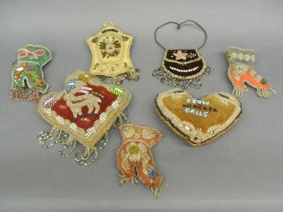 Niagara Falls beadwork: Collection of seven turn of the century Native American beadwork items from Niagara Falls. Includes pincushions, change purse and a match holder dated 1906. Wear and some damage. Up to 8" high. ESTIMA