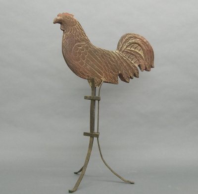 Wooden Rooster weathervane: A late 19th/early 20th century carved wooden Rooster weathervane. Old Red paint over White. Wear and minor damage. Includes an Iron stand. 17" long. ESTIMATE $200-300