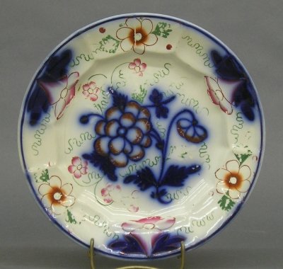 Gaudy Welsh plate: A 19th century Ironstone plate with Gaudy Welsh decoration. Blue floral transfer with polychrome enameling. Wear, loss to enameling, flake on foot. 10" diameter. ESTIMATE $50-100