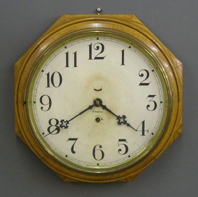 Waterbury gallery clock: A turn of the century Waterbury "12 Inch Lever" model gallery clock. 8 day spring driven time only movement. Octagonal molded Oak case. In good running order. Label 50% intact on back. Older finish wi