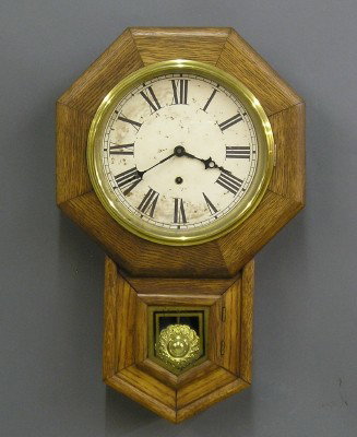 Sessions Schoolhouse clock: A turn of the century Sessions Schoolhouse clock. 8 day spring driven time only movement with a 10" paper dial. Oak short drop case with painted lower glass. In running order. Refinished with minor we