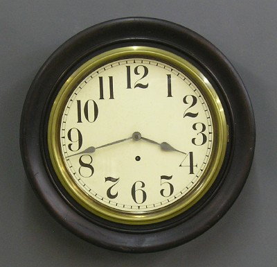 Sessions gallery clock: A turn of the century Sessions "Foyer" model gallery clock. 8 day spring driven time only movement with a 11" paper dial. Mixed wood case with molded frame and Brass bezel. Paper label on back 80% int