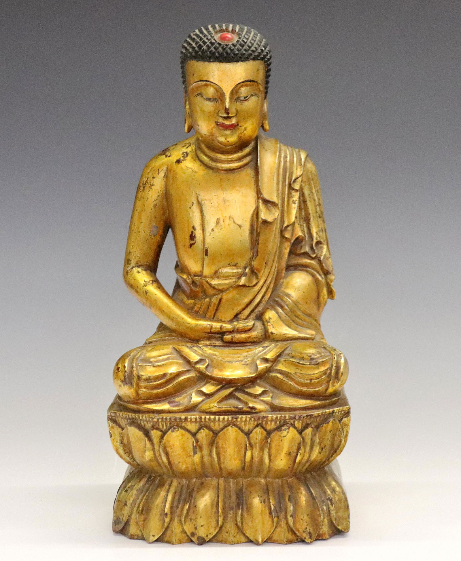 Chinese Gilt Wood Buddha: An early Chinese Gilt Wood Buddha statue. Hand-carved Buddha seated in meditation upon a Lotus Leaf base, decorated with Black and Red accents. Repaired crack to front legs and base, wear to Gilt expo