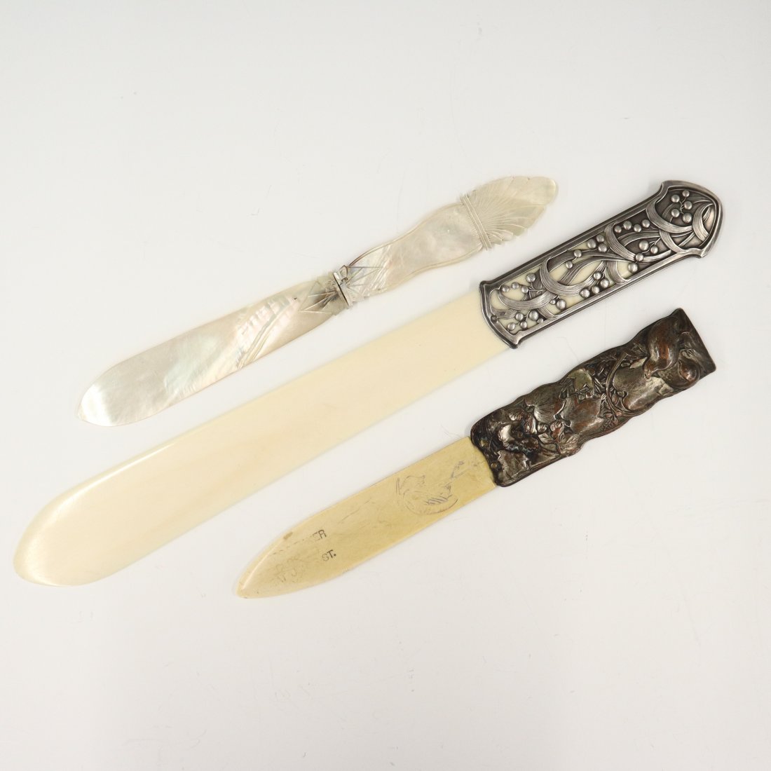 2 Page Turners & Letter Opener: Two turn of the century page turners and letter opener. One constructed of Mother of Pearl, two of Bone. One Bone with French Silver handle in Art Nouveau style, the other with Silverplated handle in 