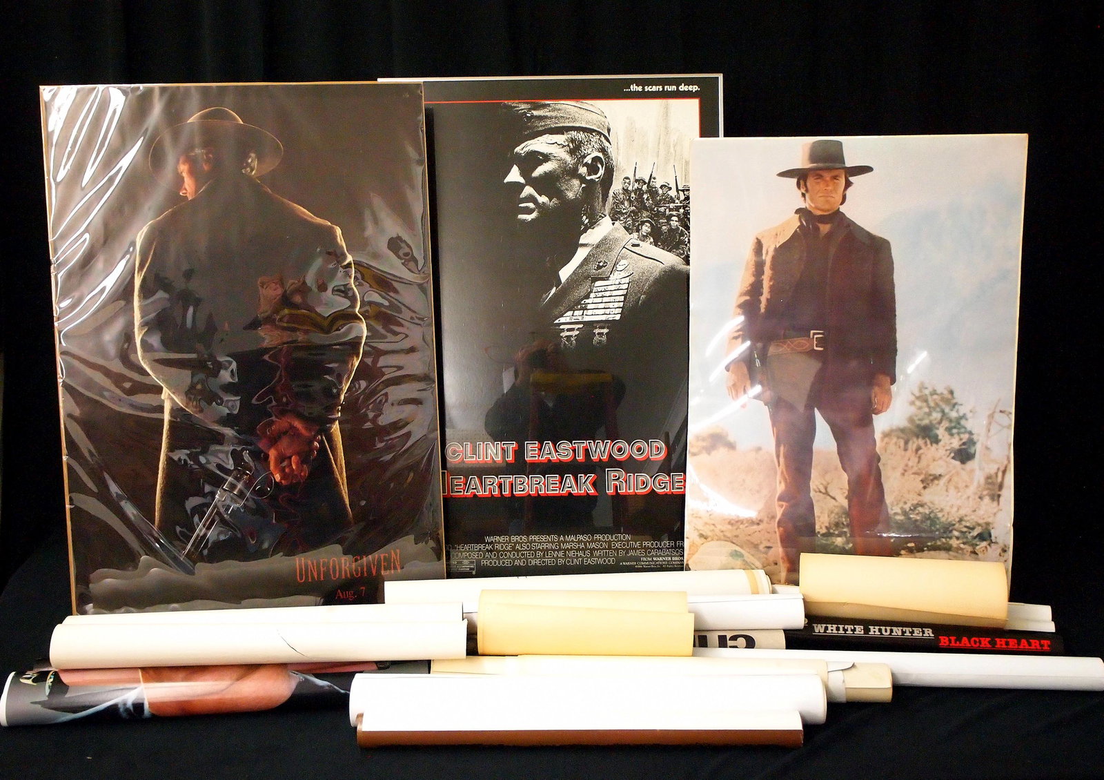 Clint Eastwood Ephemera Lot: A collection of vintage Clint Eastwood ephemera. Includes flat movie posters from "Heartbreak Ridge" (1986), "Unforgiven" (1992), and rolled posters from "A Perfect World" (1993), "The Rookie" (1990),