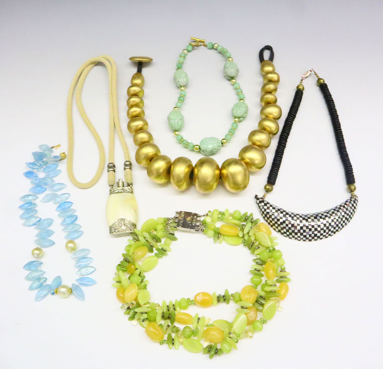 6 Necklaces: Six necklaces made from various materials including Glass, Pearl, Mother of Pearl, Jade, polished Bone, Ebony, and "monies" Foil beads. Minor wear to "monies" necklace. Up to 19" long. ESTIMATE $200-3