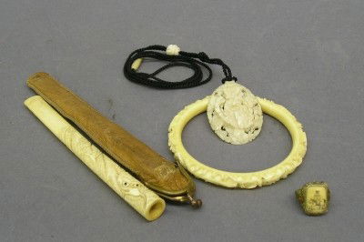Collector's lot: A four piece collectors lot including a Chinese lady's ring with Ivory and enamel work, a carved Bone Dragon bracelet and cased cigarette holder and a carved Ivory pendant. Minor wear. ESTIMATE $100-1