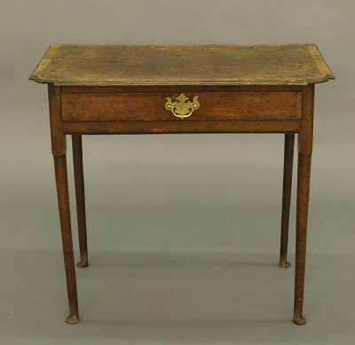 18th century Oak lowboy: An 18th century English Oak lowboy. Shaped molded top with Mahogany edge banding above a single dovetailed drawer with molded and banded face, supported by slender turned legs and delicate button feet
