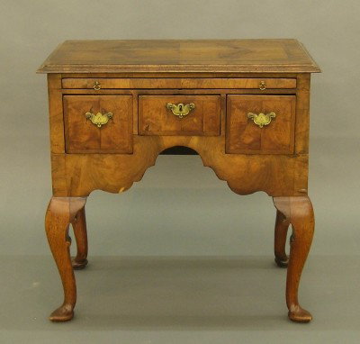 Walnut QA lowboy: An 18th century English Walnut lowboy. Molded top with book matched veneer and Mahogany crossbanding above a pull out slide and three lower drawers, a deeply scalloped apron and shaped Cabriole lags w