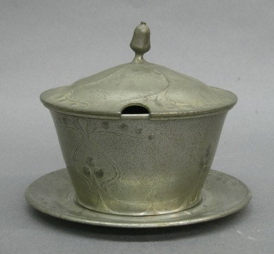 Kayserzinn covered sauce bowl: A turn of the century Kayserzinn Art Nouveau Period Pewter covered sauce bowl with underplate. Cast Lilly of the Valley design. Oval mark "KAYSERZINN, 4399". Some surface wear, finial bent. 5" diamete