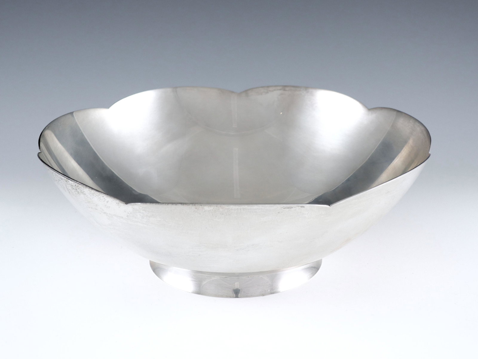 Tiffany & Co. Sterling Bowl: A Tiffany & Co Sterling Silver center bowl. Footed round form with scalloped rim. Impressed "Tiffany & Co. Makers" and "Sterling" with "23843" pattern number. 20.36 troy ozs total weight. Minor surfac