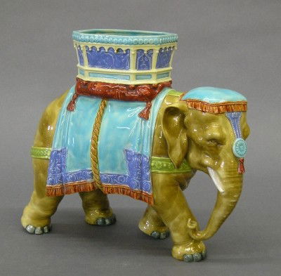 Royal Worcester Majolica Elephant: A 19th century Royal Worcester Majolica Elephant designed by James Hadley, and produced for sale in the US for "Richard Briggs, Boston". Molded body depicts an Elephant with howdah, in a multicolor gl