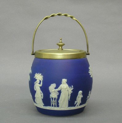 Wedgwood Jasperware biscuit barrel: A turn of the century Wedgwood Jasperware biscuit barrel with Silver plated top and swing handle. Blue Jasper dip body with Classical figures in White relief. Impressed mark "WEDGWOOD" only. Minor wea
