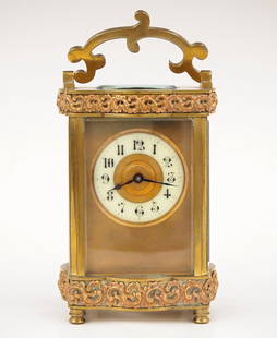 French Carriage Clock: An early 20th century French carriage clock. 8-day time only movement with Gilded dial, porcelain chapter ring and Arabic numerals. Brass case with scrolled swing handle, molded top and base with