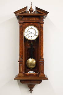 German Wall Clock: A late 19th century German wall clock. 8-day time and strike movement with two-part porcelain dial, Roman numerals and molded Brass bezel, on demand strike with pull string winding, serial #20694. 