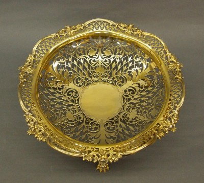 Edwardian Sterling Fruit bowl: A turn of the century British Sterling Silver fruit bowl with Gold wash. Reticulated design with cast floral rim, engraved central medallion and three paw feet. Made by James Dixon and Son, Sheffield,