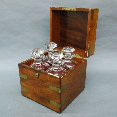 Irish Cellerette: A 19th century Irish Cellerette by "Austin, Dublin". Brass banded Mahogany case with four Cut Crystal bottles with faceted stoppers. Some wear, chips in bottle rims. 10 1/4" high overall. ESTIMATE $20